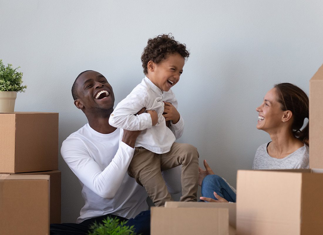 About Our Agency - Happy Family and Young Child Laugh and Celebrate Moving into Their New Home
